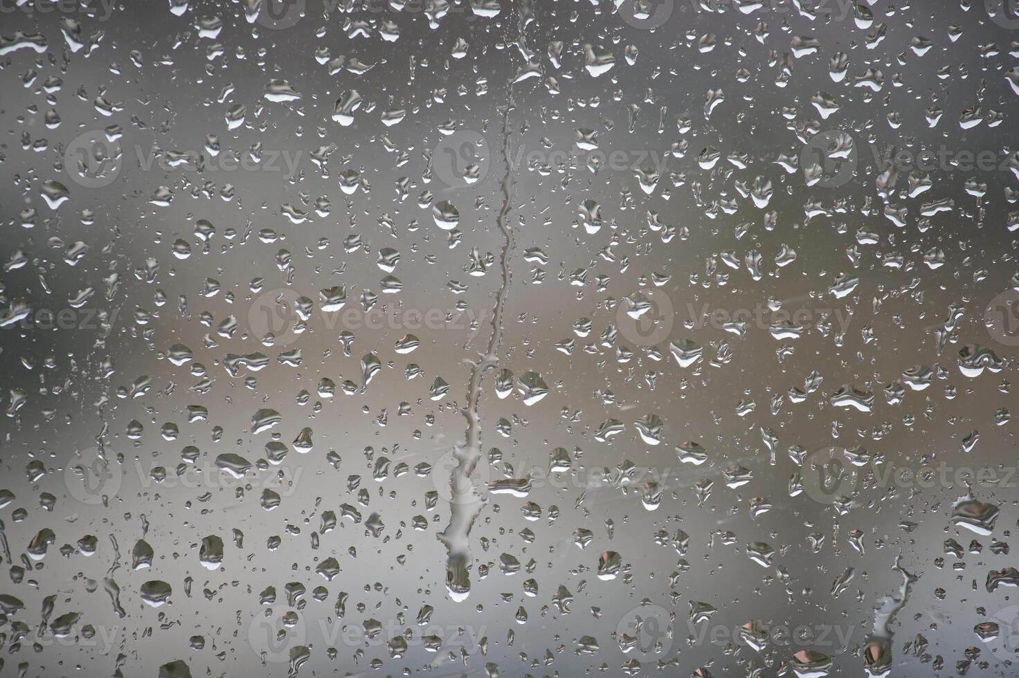 A close-up view of raindrops creating an artistic pattern on a window, a rainy day. photo