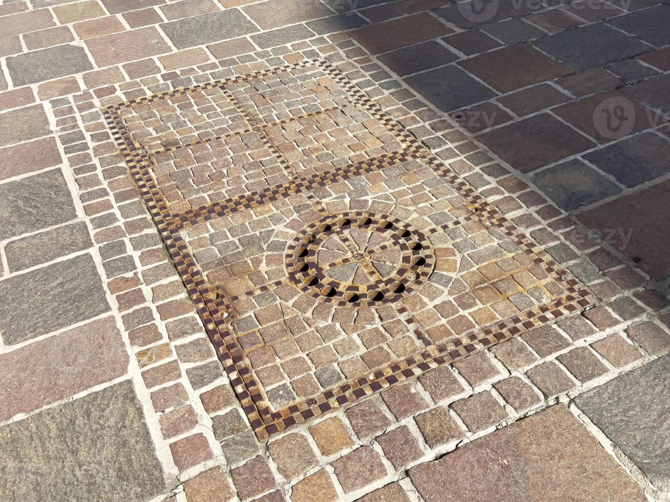 Intricate cobblestone mosaic design on stone pavement with geometric patterns photo