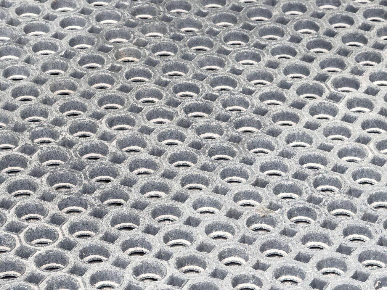 Close-up of worn circular metal grid with repeated hexagonal pattern photo
