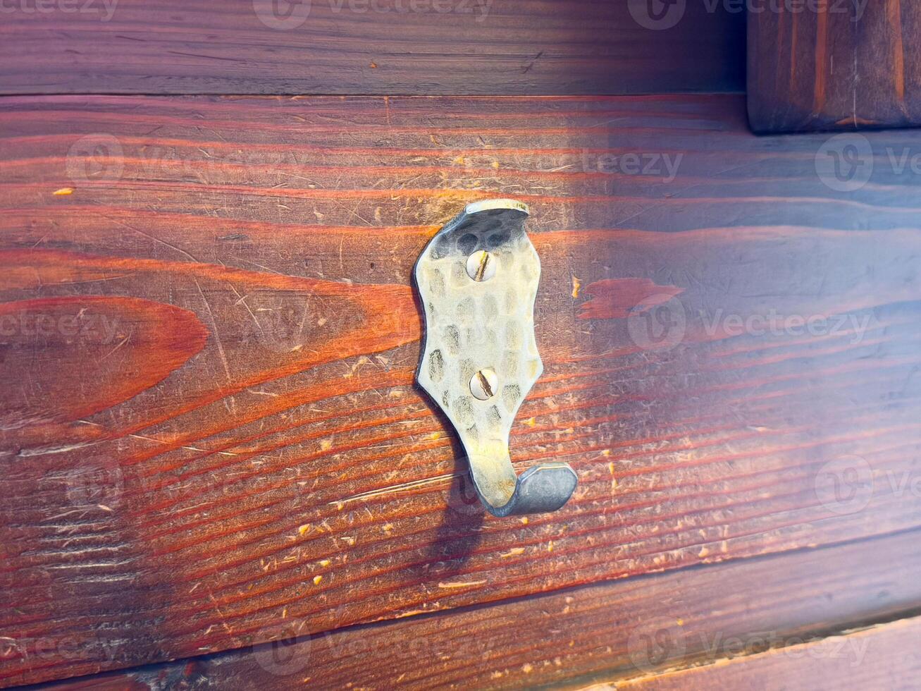 Rustic metal hook on weathered wooden plank wall outdoors photo