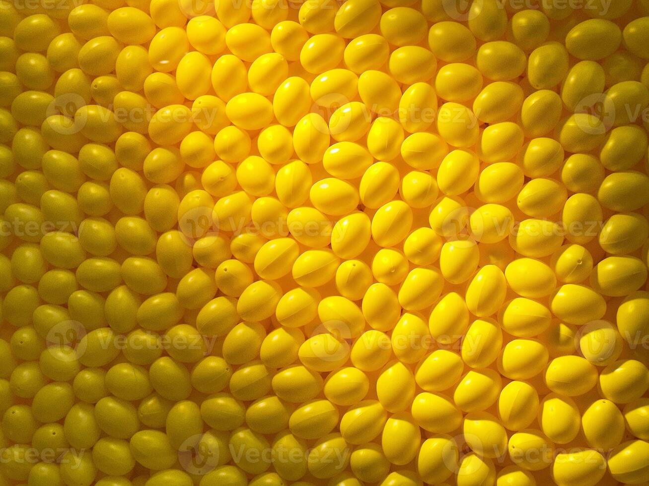 Bright yellow pattern of randomly arranged oval shapes creating a vibrant textured surface photo