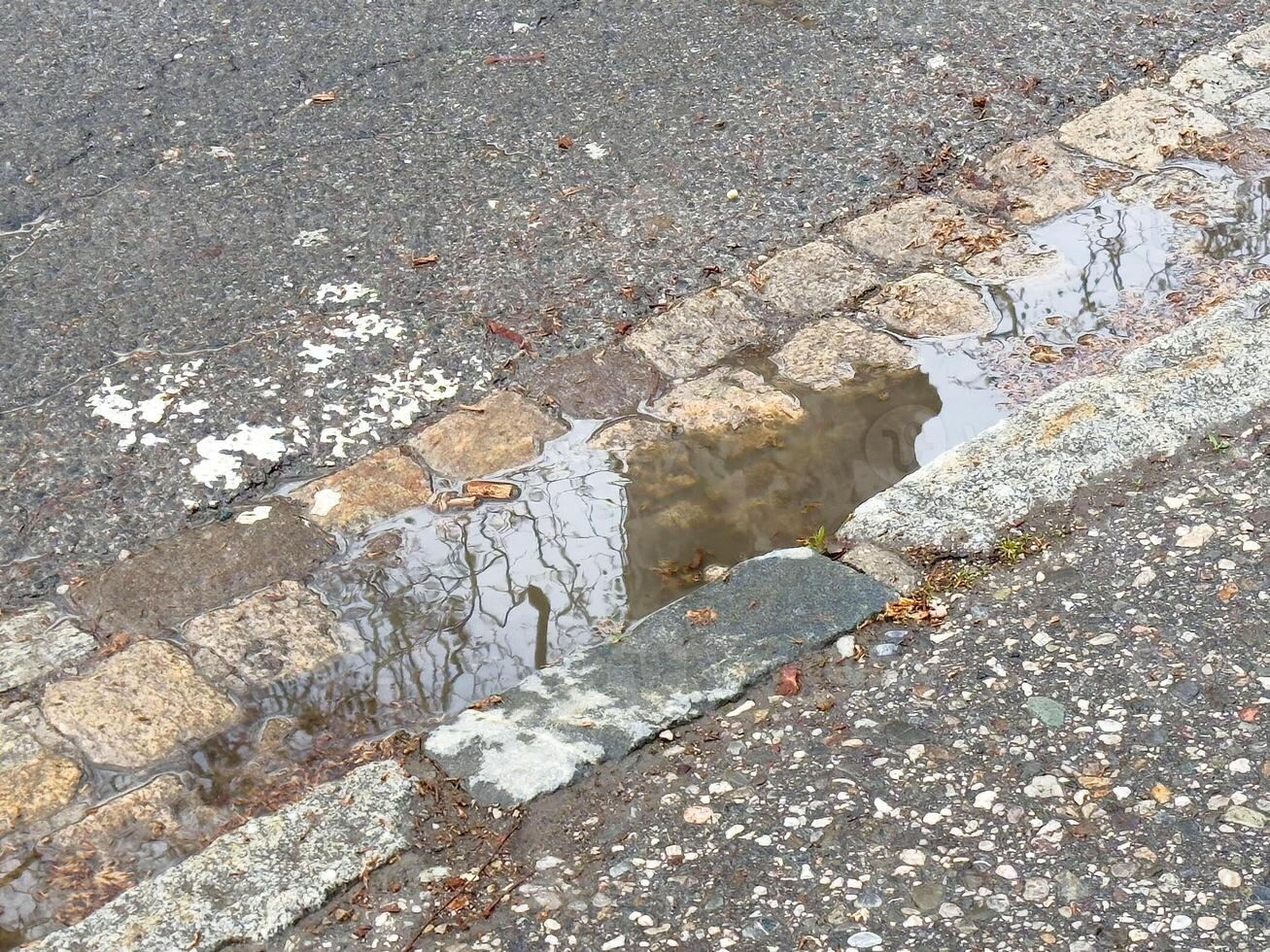 Rainy day reflection in a street puddle on cobblestones photo