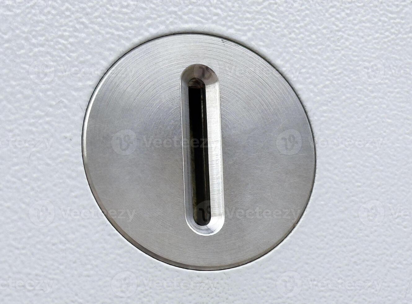Close-up of silver keyhole on white textured surface photo