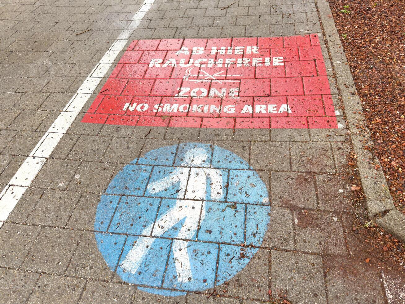 No smoking area and pedestrian zone markings on pavement photo