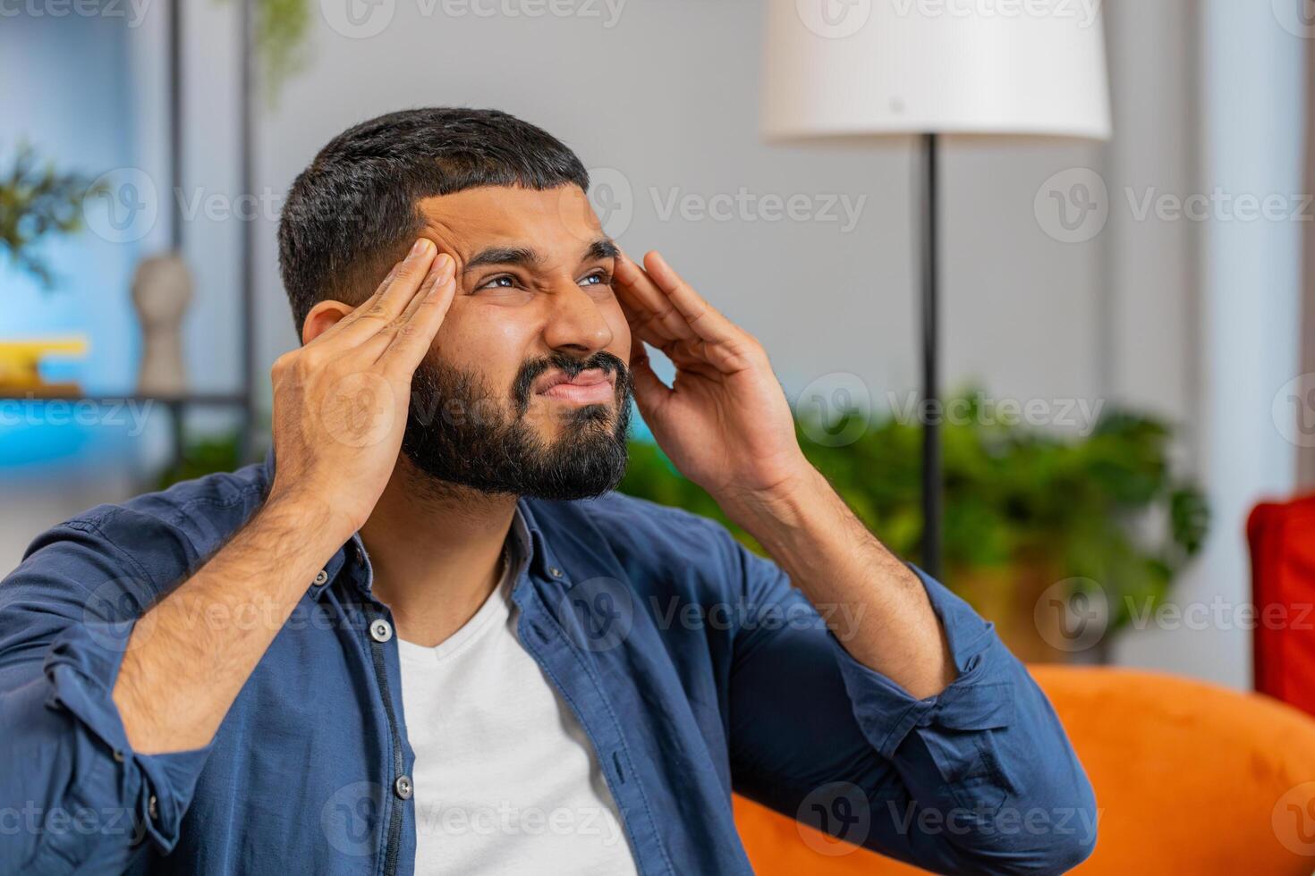 Sick ill Indian man rubbing temples to cure headache problem suffering from tension migraine stress photo