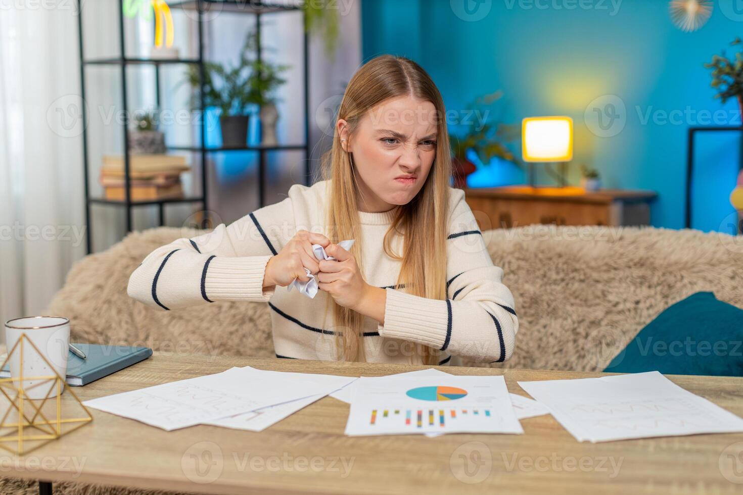 Caucasian woman frustrated with bill errors at home on table, holding documents, feeling bankrupt photo