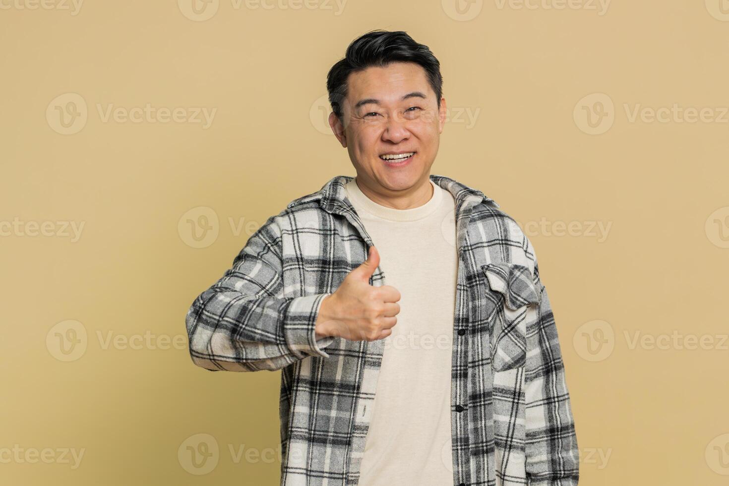 Asian man raises thumbs up agrees give positive reply recommends advertisement likes good idea photo