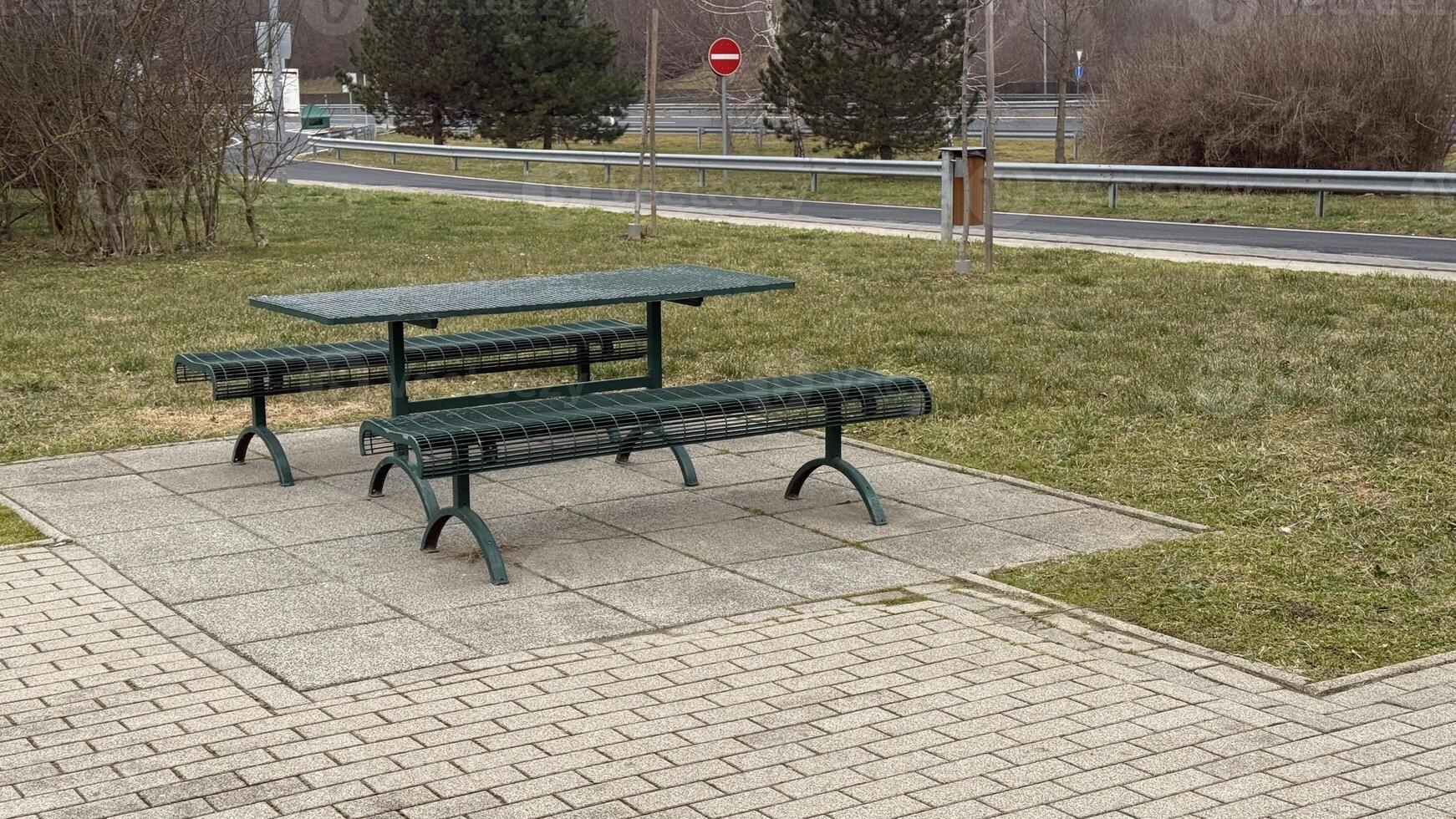 Empty picnic tables on a paved area, outdoors leisure concept, spring gatherings, park relaxation, urban picnic scene photo