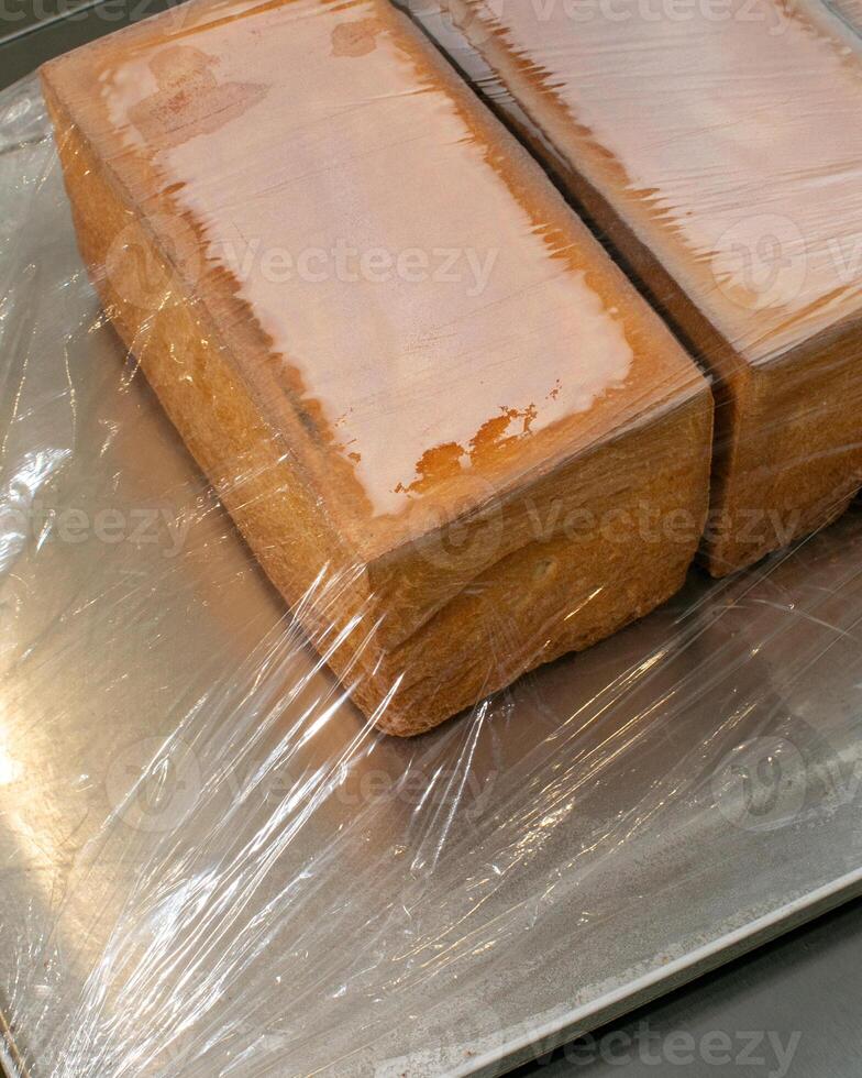 Freshly baked loaves wrapped in plastic, perfect for holiday gatherings, homemade bread baking, rustic kitchen atmosphere photo