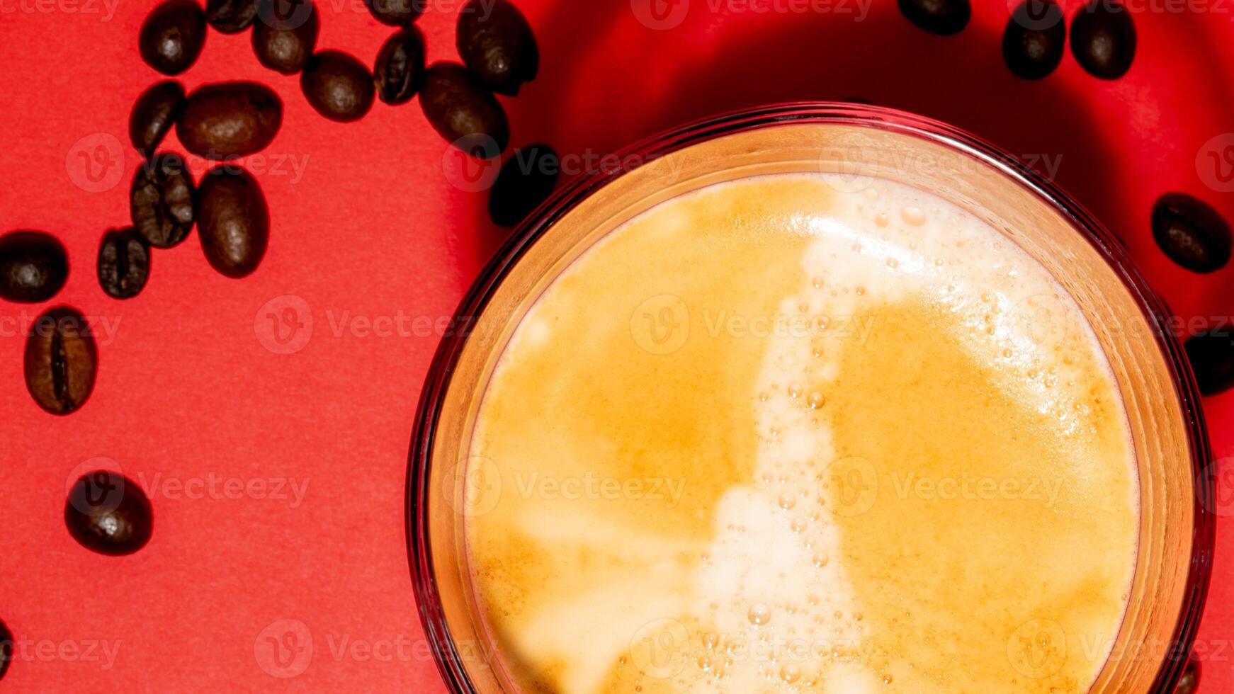 Creamy espresso with coffee beans on vibrant red backdrop, morning refreshment, energy boost, International Coffee Day celebration photo