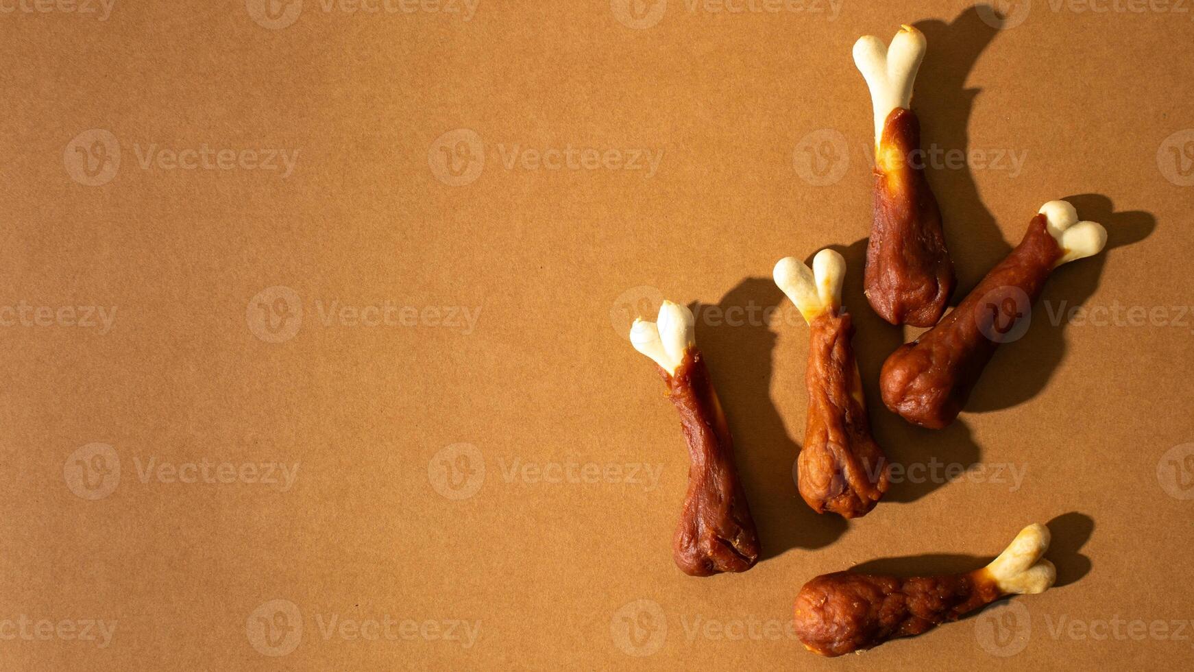 Five realistic dog bones on a brown background, representing pet care and playful treats, perfect for National Dog Day photo