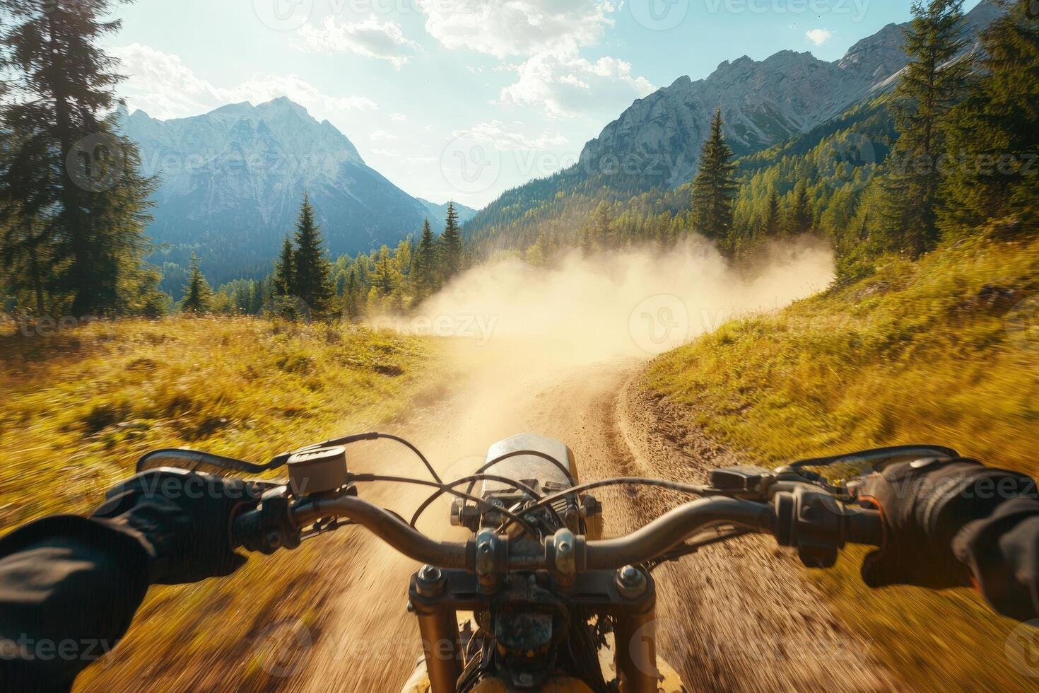 A rider navigates a winding dirt path on a motorcycle, surrounded by tall trees and majestic mountains. Dust rises behind the bike as it speeds through the vibrant natural landscape. photo