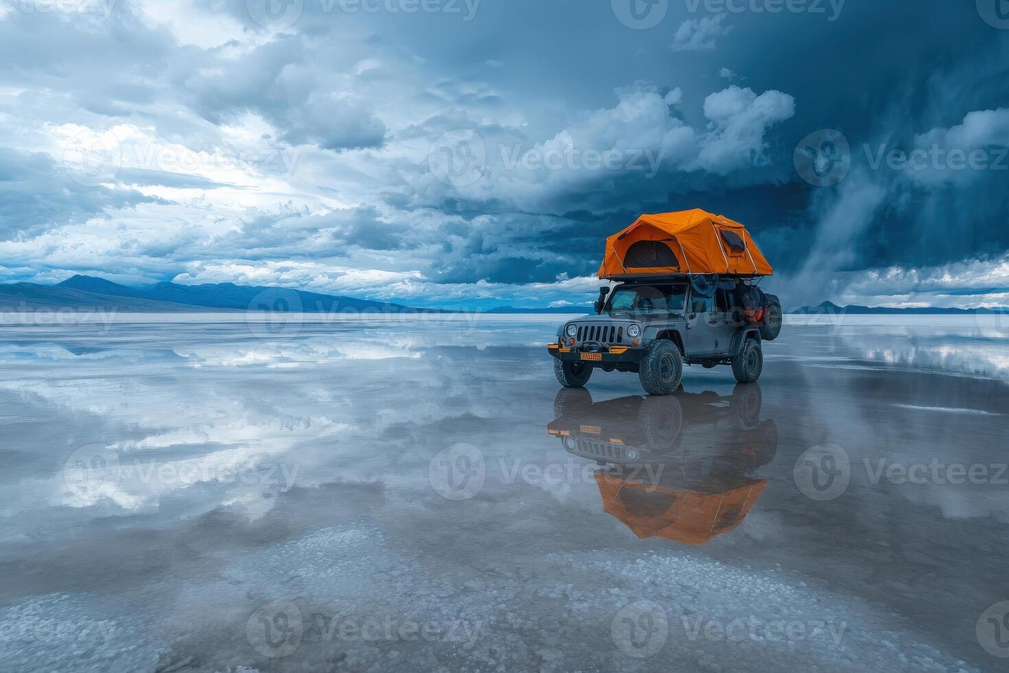 A rugged jeep equipped with a rooftop tent stands on a vast salt flat reflecting dark, stormy clouds. The scene captures the allure of adventure amidst natures majesty. photo