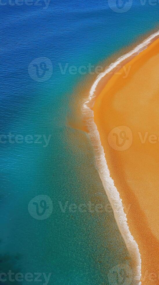 Aerial View of Vibrant Orange Sand Meeting Turquoise Water on Serene Beach Shoreline photo