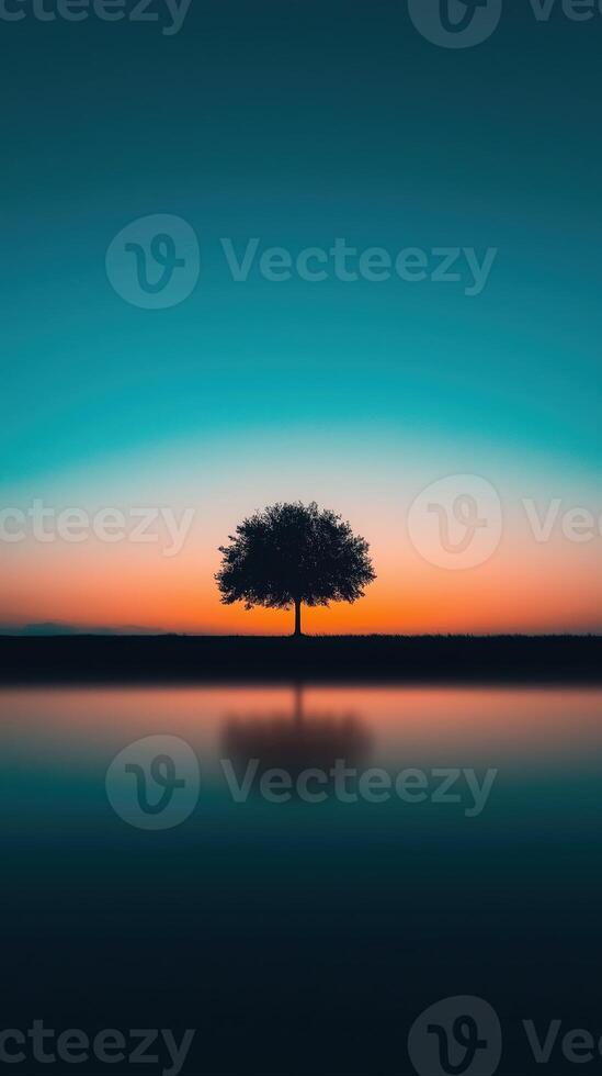 Serene Lonely Tree Glowing Under Dreamlike Sunset Sky with Reflection on Calm Water photo