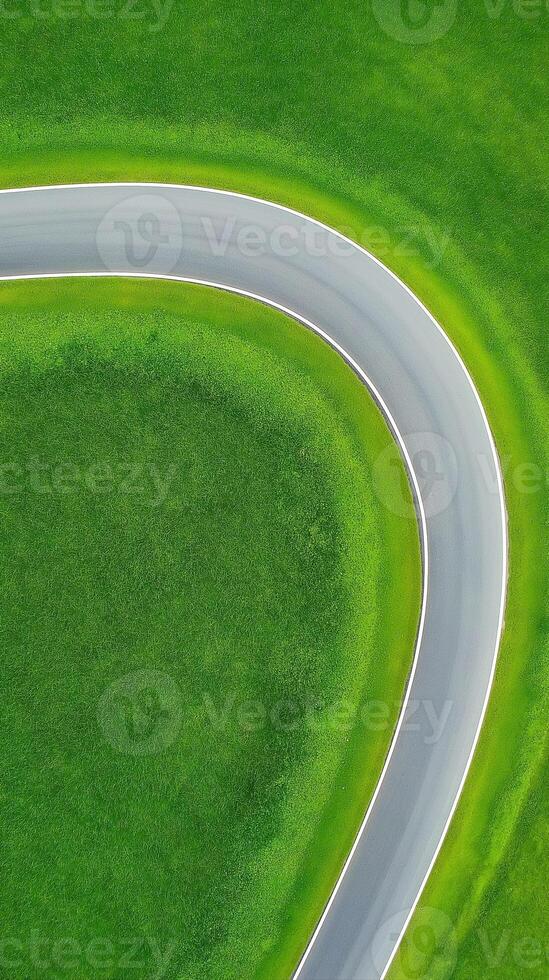 Winding Road Cutting Through Symmetrical Farmland with Lush Greenery and Smooth Curves photo