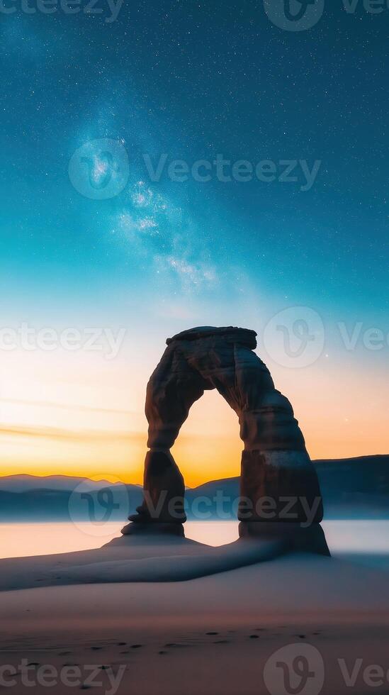 Majestic Black Rock Arch Glowing Under Twilight Sky with Galaxy in Background photo