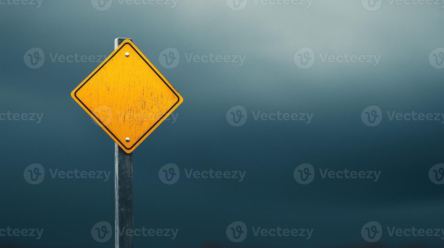 Empty Yellow Caution Sign Against Dark Clouds in an Urban Landscape photo