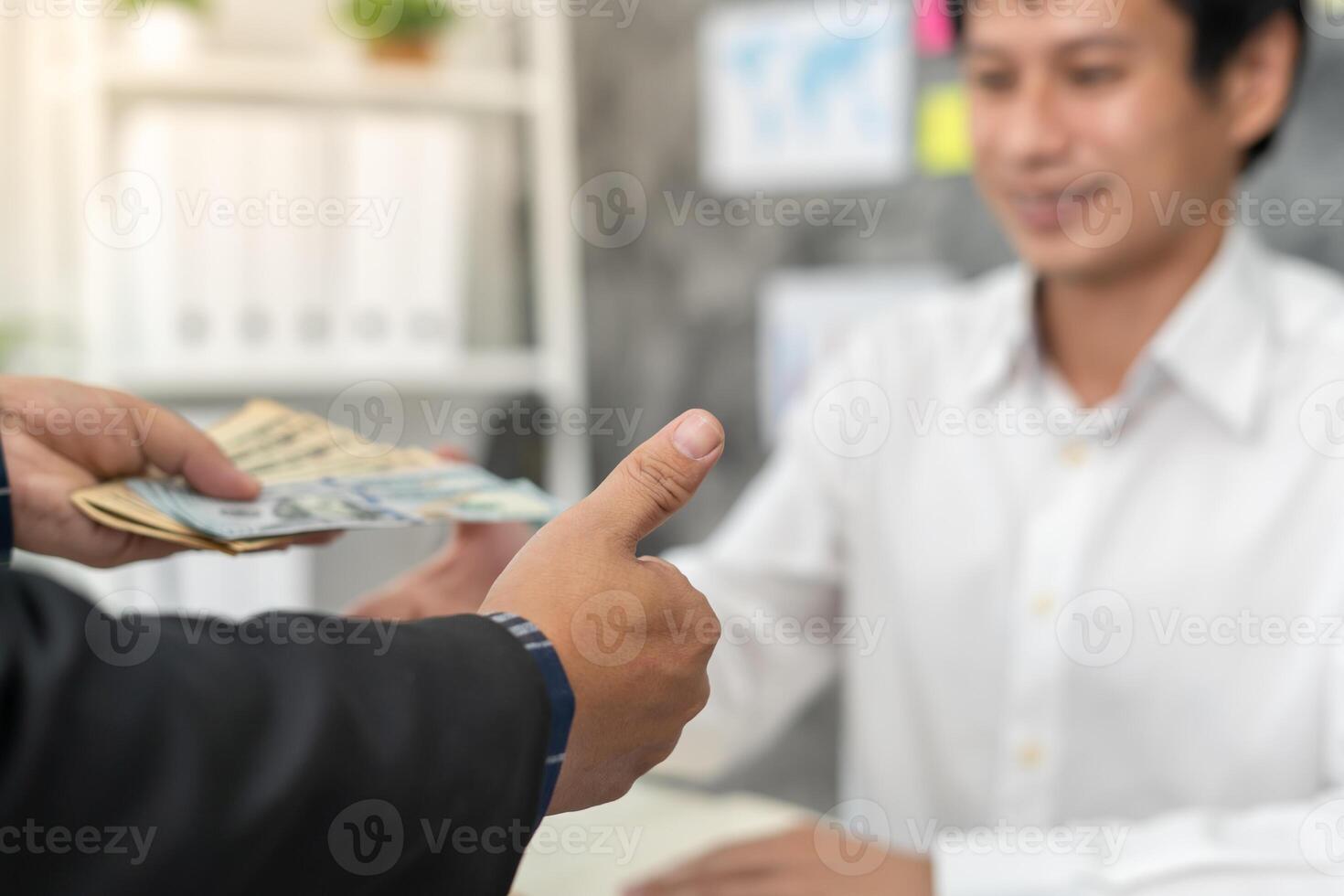 Businessmen receive salary or bonuses from management or Boss. Company give rewards to encourage work. Smiling businessman enjoying a reward at the desk in the office photo