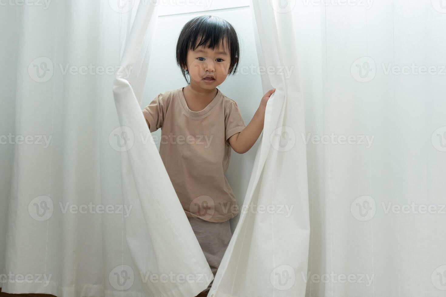 children kid playing hide and seek standing next wall house, Adorable child having fun in the home. happy family have fun with kids, activity, learning, activity, game, meditation photo