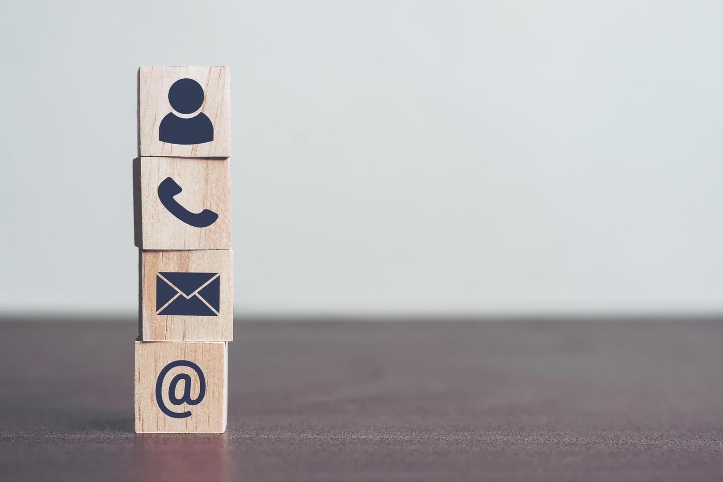 Contact us concept, Profiles and detailed personal information to identify yourself. Wooden blocks in his hand with icon telephone, mail and email, Online business communications concept, copy space photo