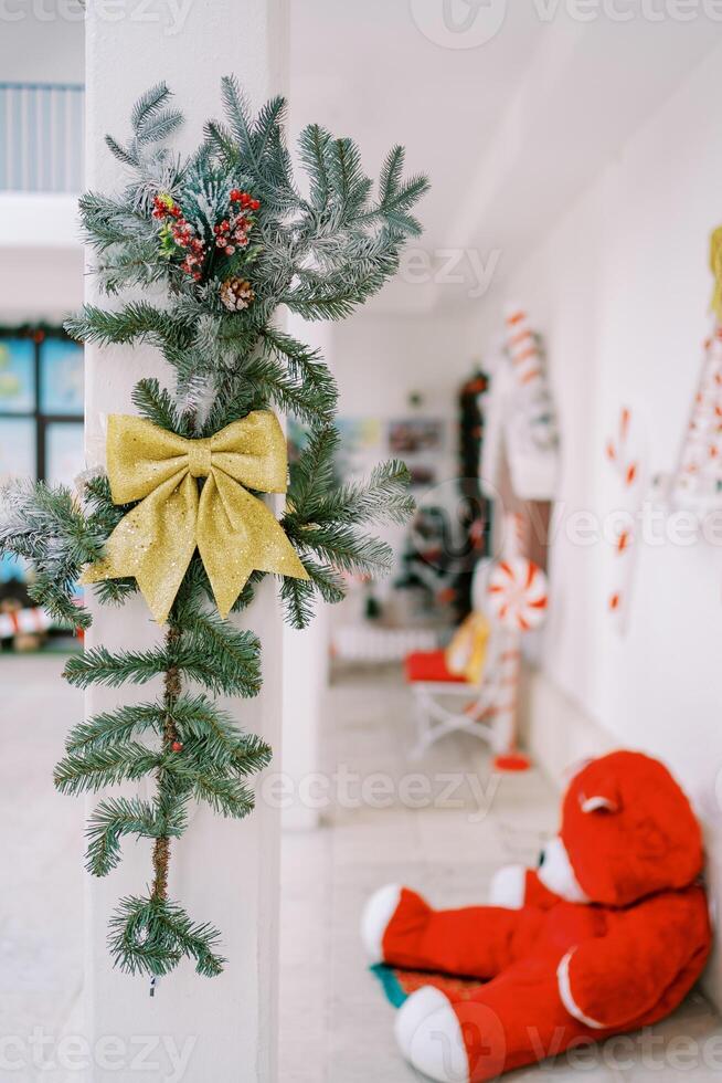Pillar decorated with a garland and a bow against the background of New Year decor photo