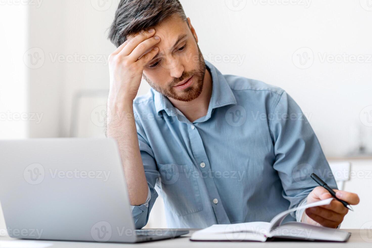 Tight Schedule. Tired Businessman Checking Business Appointments In Notepad At Office, Planning His Working Timetable, Copy Space photo