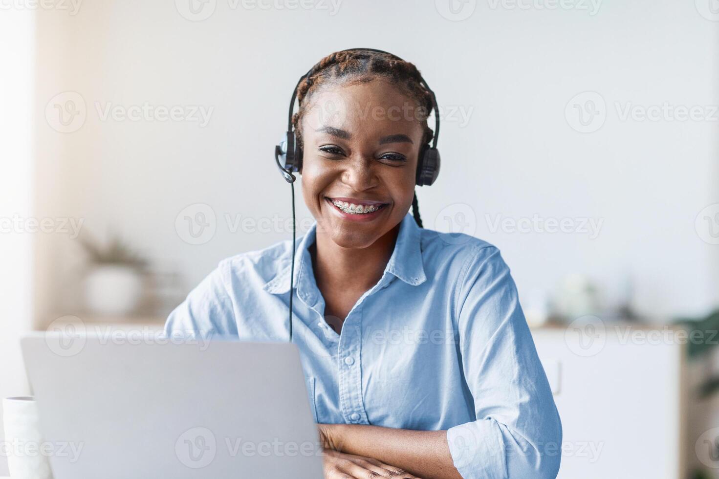 Portrait Of Smiling Black Woman Call Center Operator At Workplace In Office, Sitting At Desk With Laptop, Looking Ar Camera, Copy Space photo