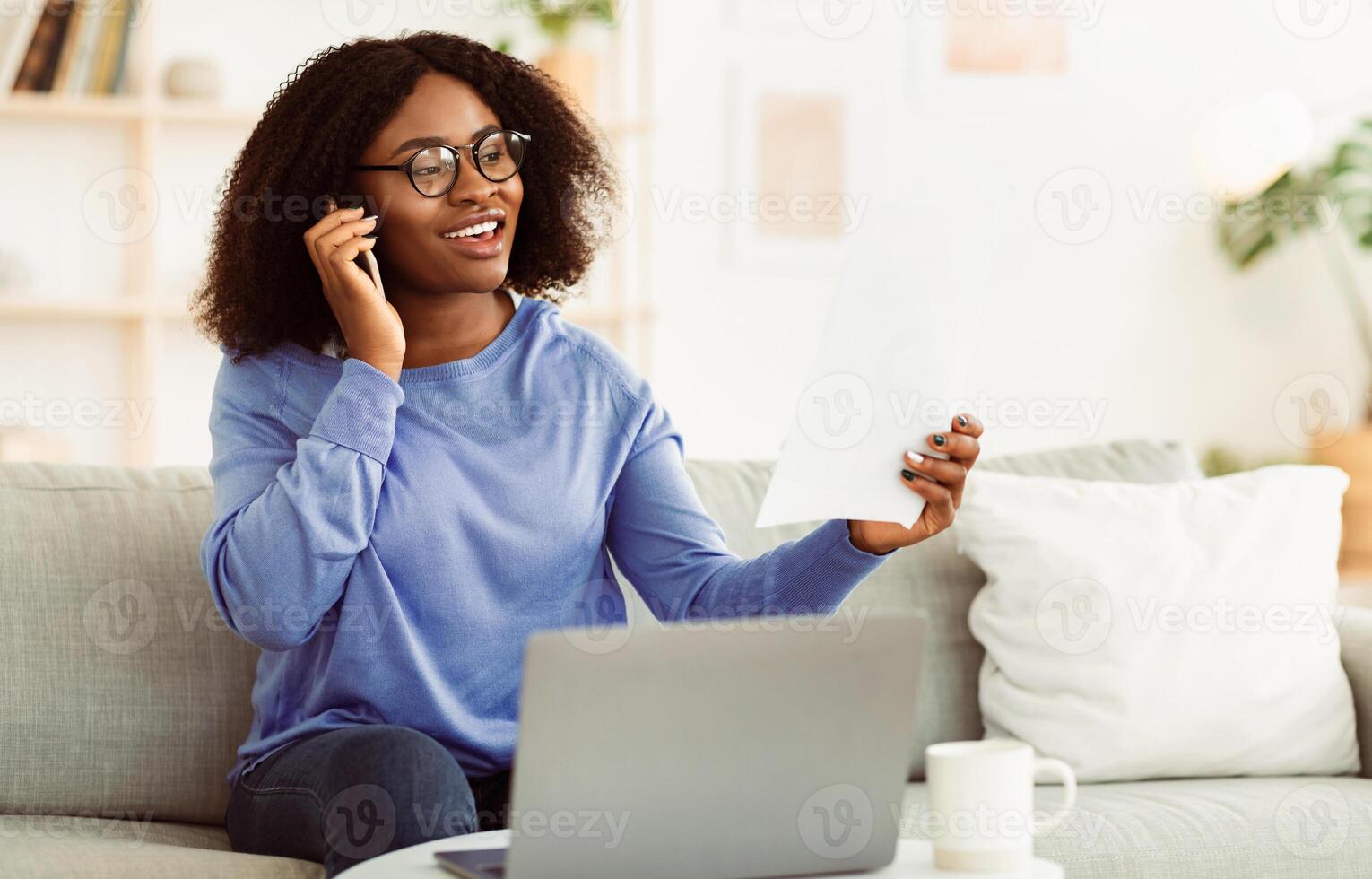Home Office. Young Black Businesswoman Working With Papers And Talking On Phone At Home With Customer, Checking Financial Documents And Reports. African American Worker Managing Startup, Copy Space photo