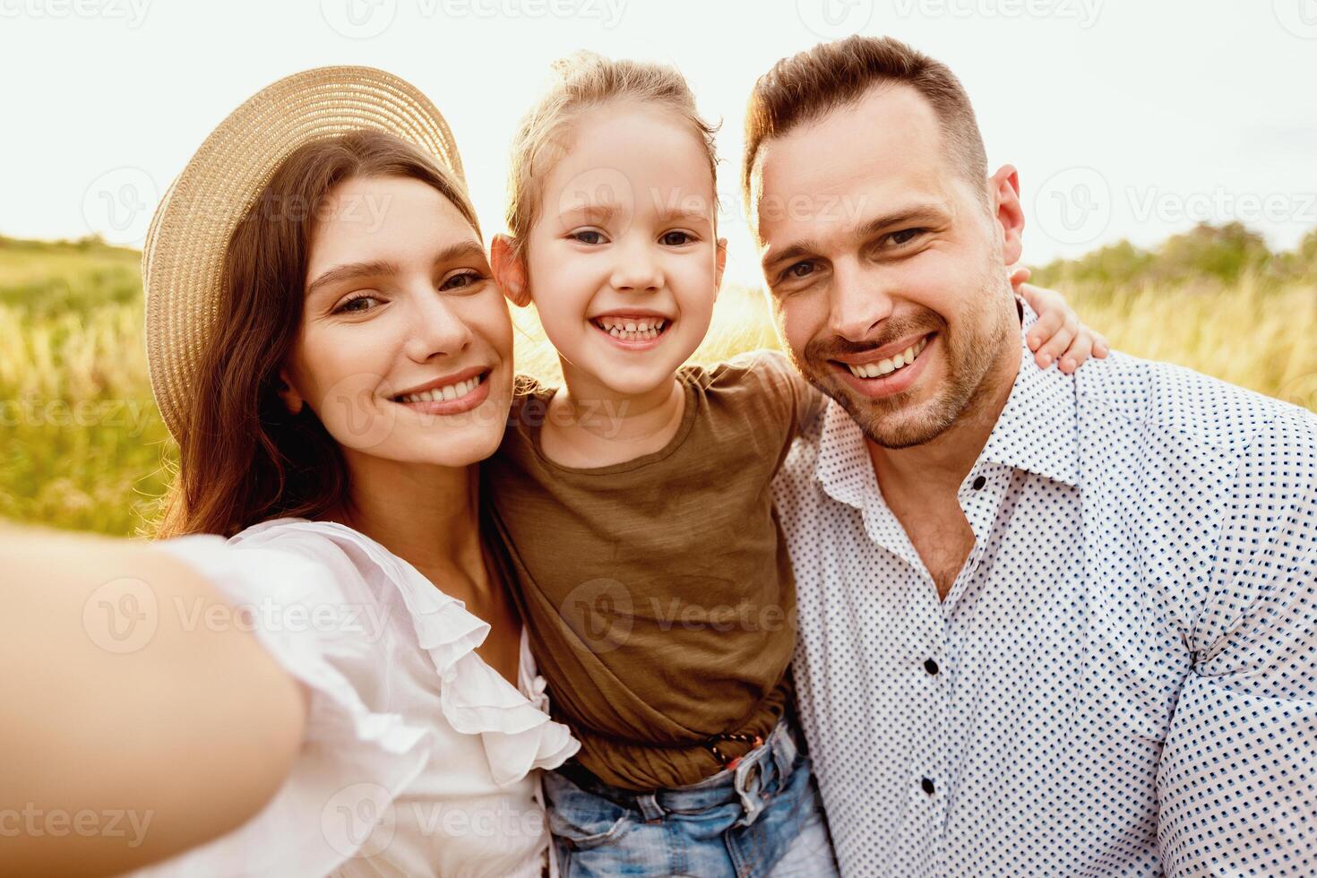 Selfie With Loved Ones. Cute mum in summer hat taking photo with her child and husband, spending time together outdoors