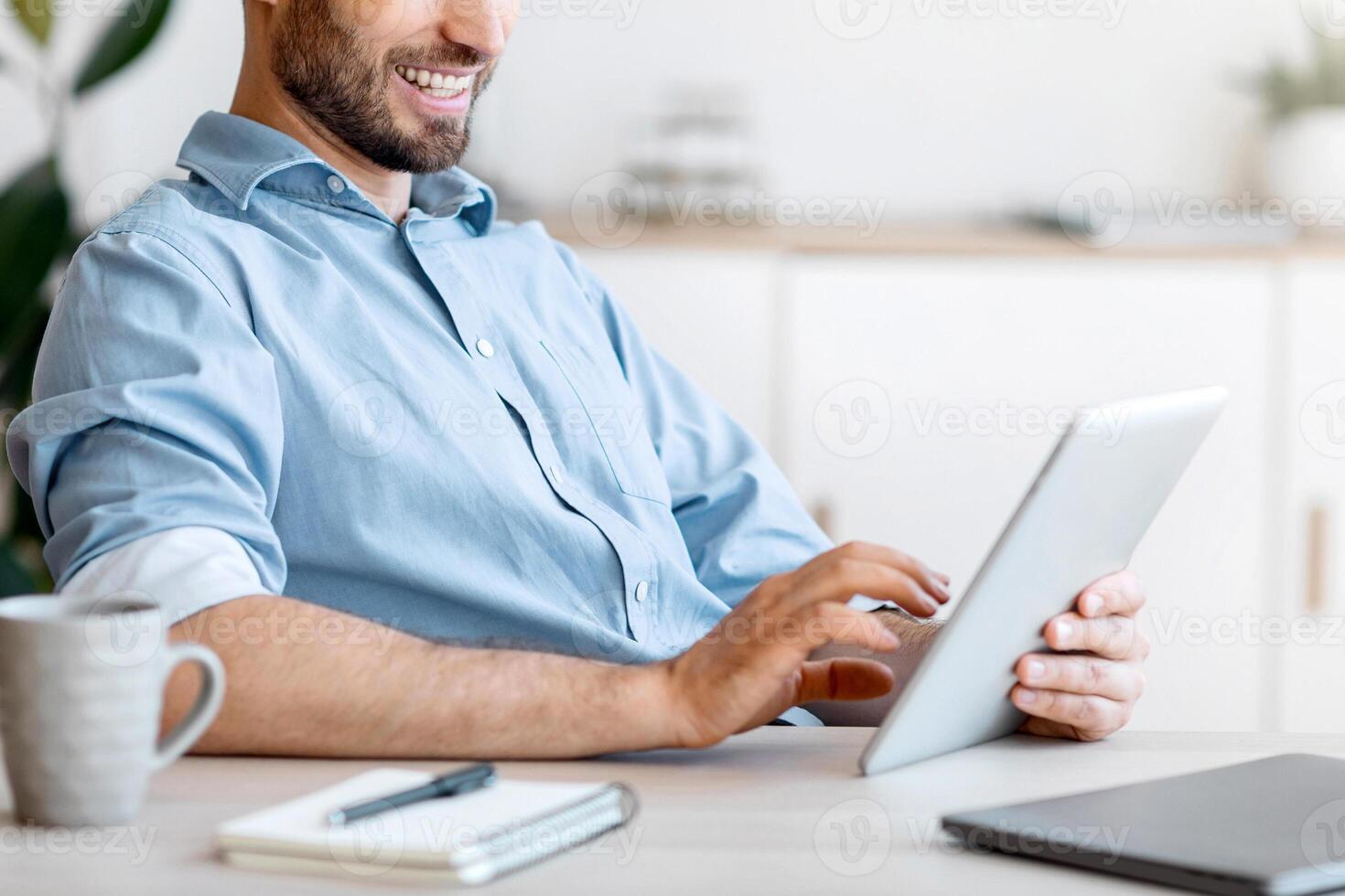 Handsome Young Businessman Using Digital Tablet At Workplace In Office, Browsing New Application Or Social Media, Free Space photo