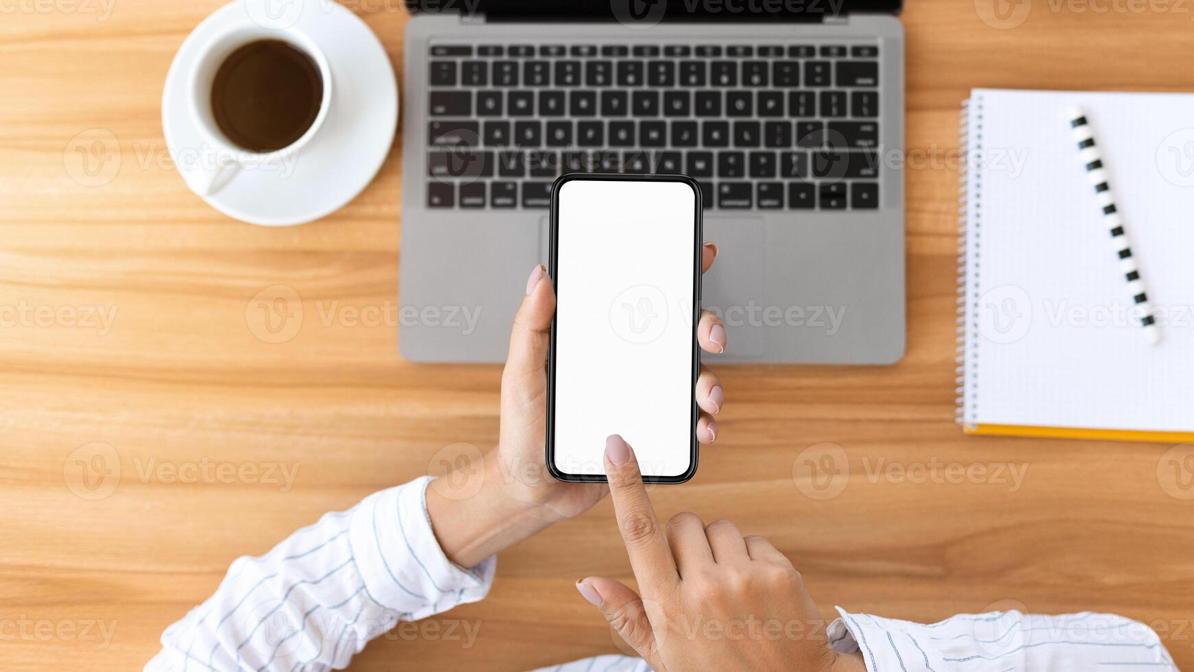 Desktop. High angle of lady touching cell phone mock up screen with finger at office table, stationery in the background photo