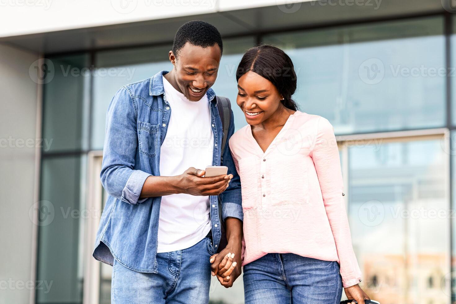 Online City Maps. Happy Black Couple Using Smartphone Outdoors Near Airport Terminal After Arrival, Smiling African American Man And Woman Planning Route With Modern GPS Application, Free Space photo