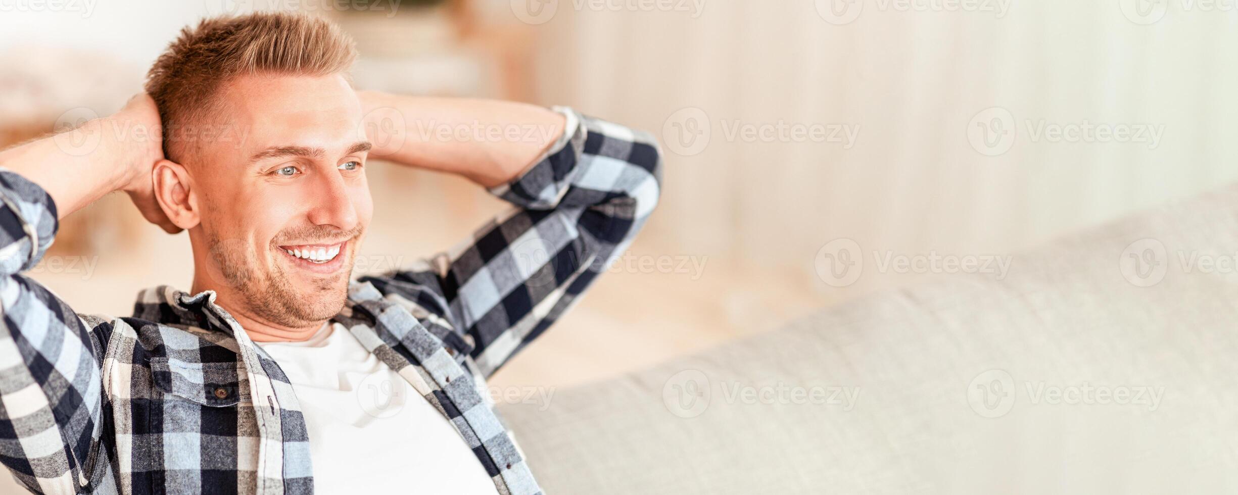 Finally Weekend Concept. Close up portrait of smiling guy having rest at home sitting on couch. Happy confident man relaxing and leaning back on sofa, enjoying free time and thinking about vacation photo