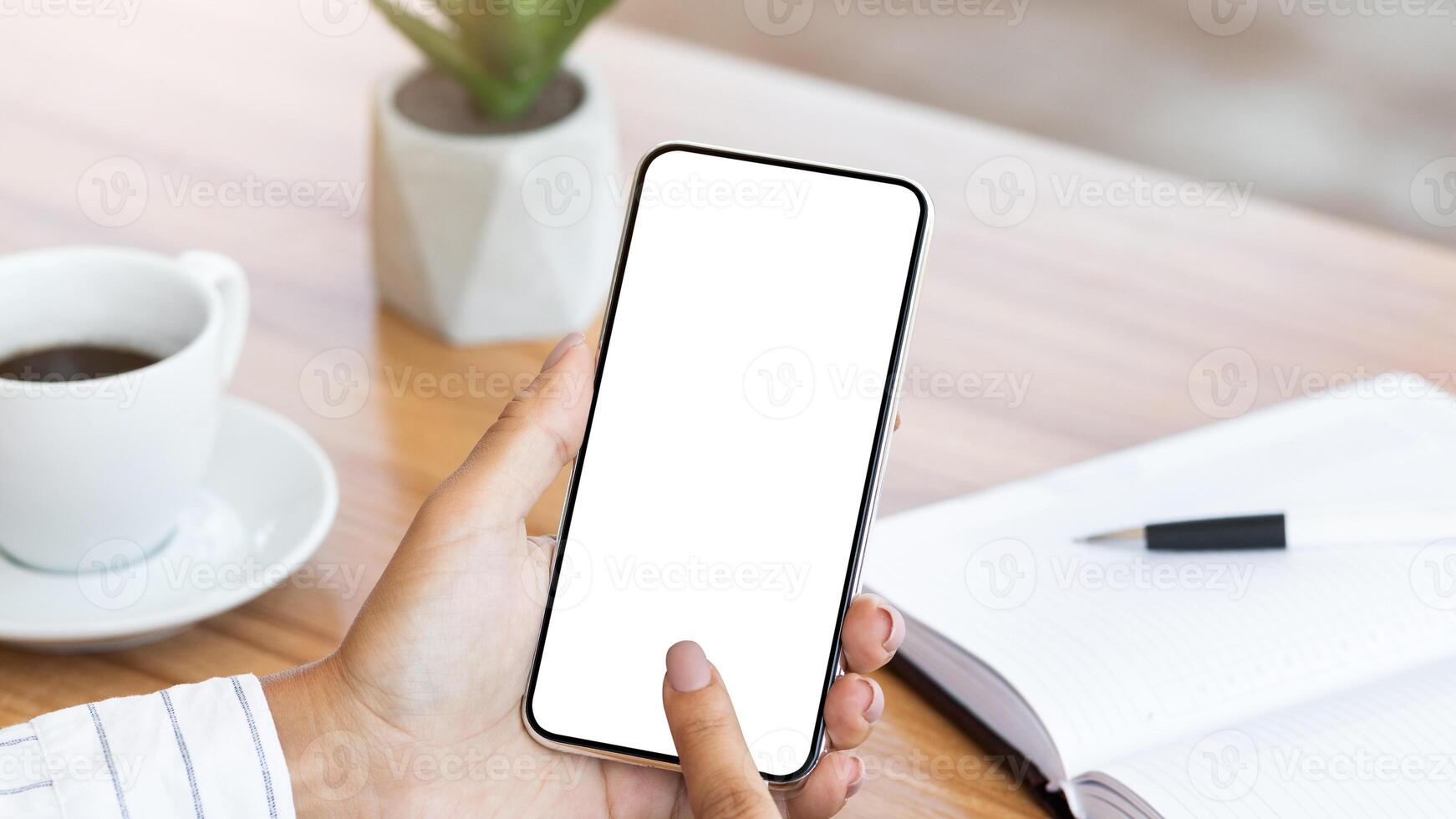 View over the shoulder of girl using cell phone, touching gadget with white blank screen, mock up, copy space photo