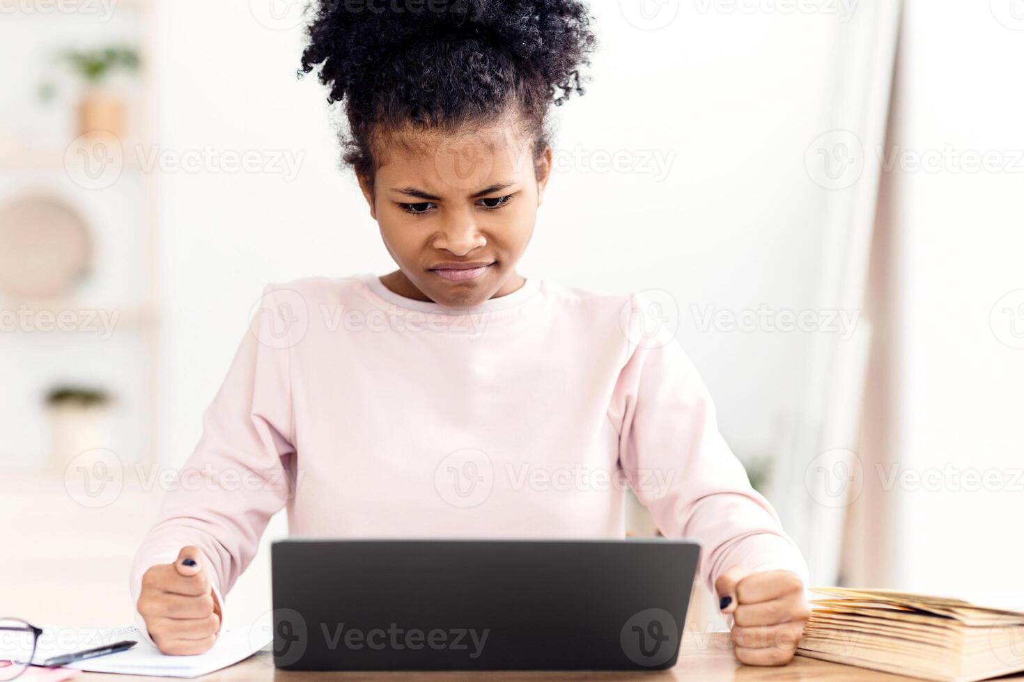 Angry Black Teen Girl At Laptop Looking At Screen Clenching Fists Sitting At Desk At Home. Computer Problem Concept photo
