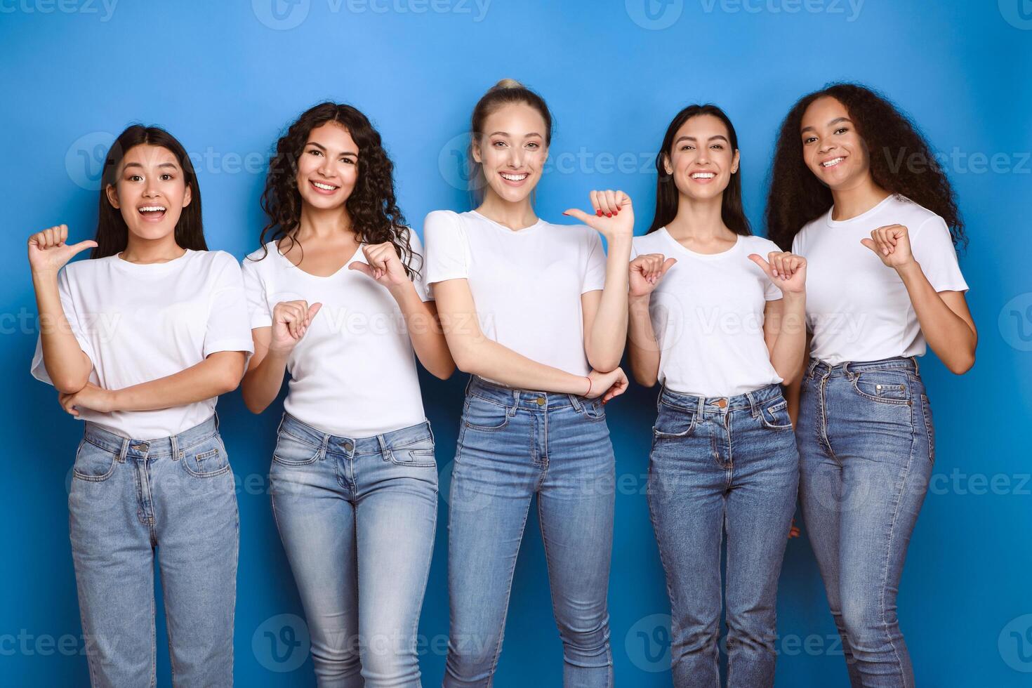 Choose Me. Diverse Girls Pointing At Themselves Smiling To Camera Posing In Studio Over Blue Background. photo