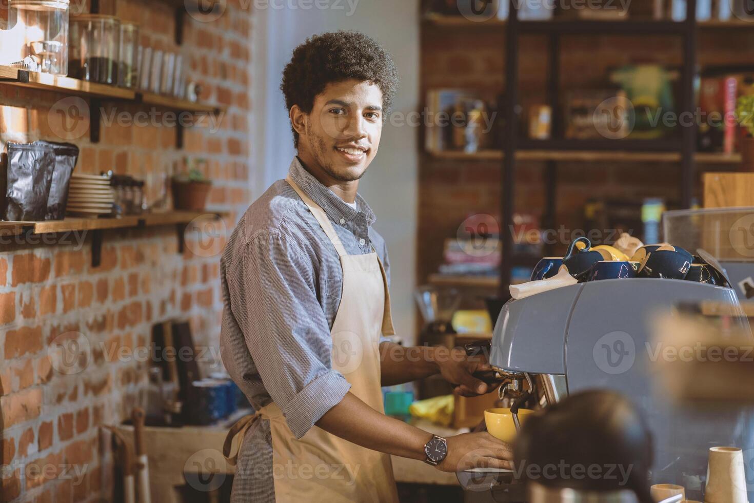 Barista job in modern cafeteria, small business owner and takeaway restaurant startup. Smiling millennial african american guy in apron makes coffee on machine at counter in cafe interior, free space photo