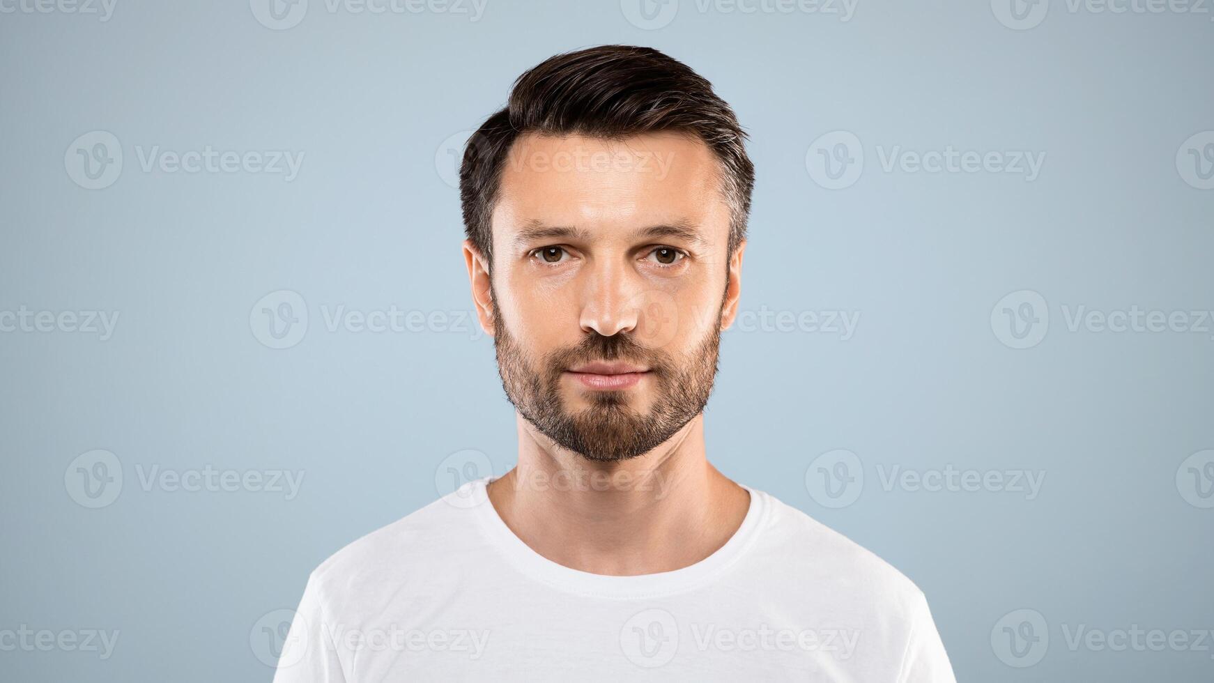Portrait of handsome bearded man over grey studio background, empty space. Middle-aged bearded man posing for male magazine or blog, youth, healthy lifestyle and male cosmetology concept photo
