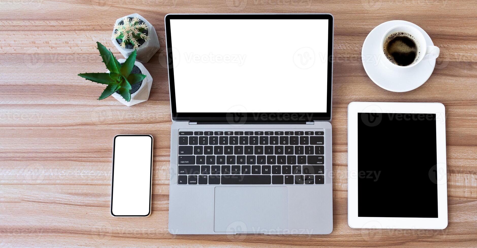 Top View Office Workplace. Flatlay of laptop, smart phone and tablet with blank screens on wooden desk, isolated mock up photo