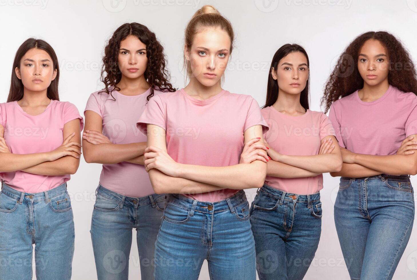 Displeased Mixed Women Standing Crossing Hands Disapproving Something Posing Looking At Camera With Serious Expression Over White Studio Background. We Don't Accept It Concept photo