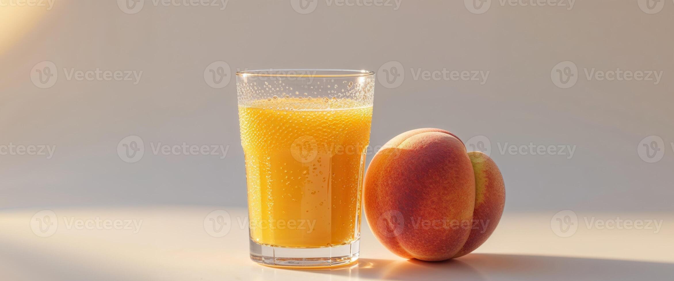 A glass of orange juice next to a peach photo