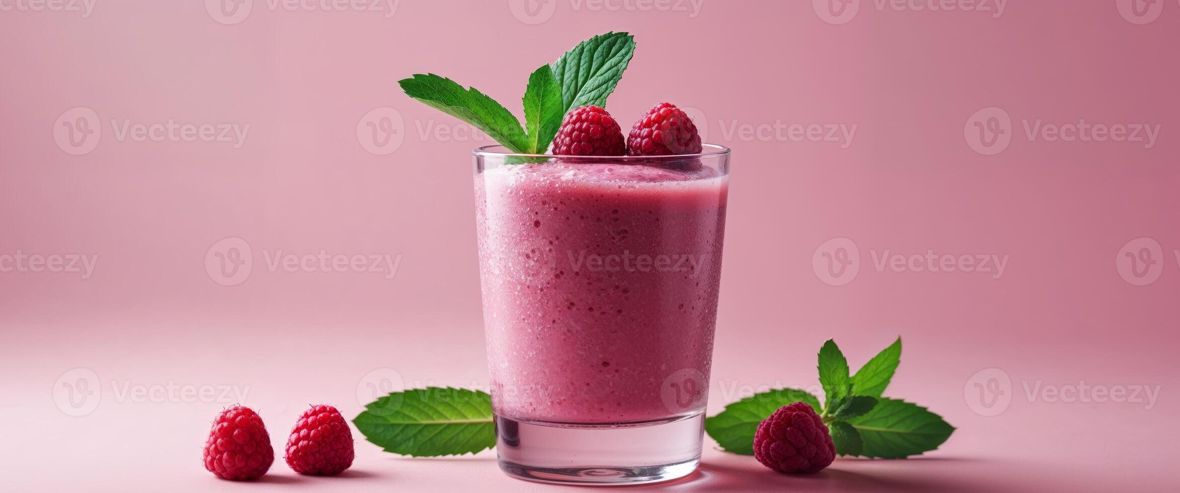 Refreshing Raspberry Smoothie Served in a Glass With Decorative Mint and Fresh Raspberries on a Pink Background. photo