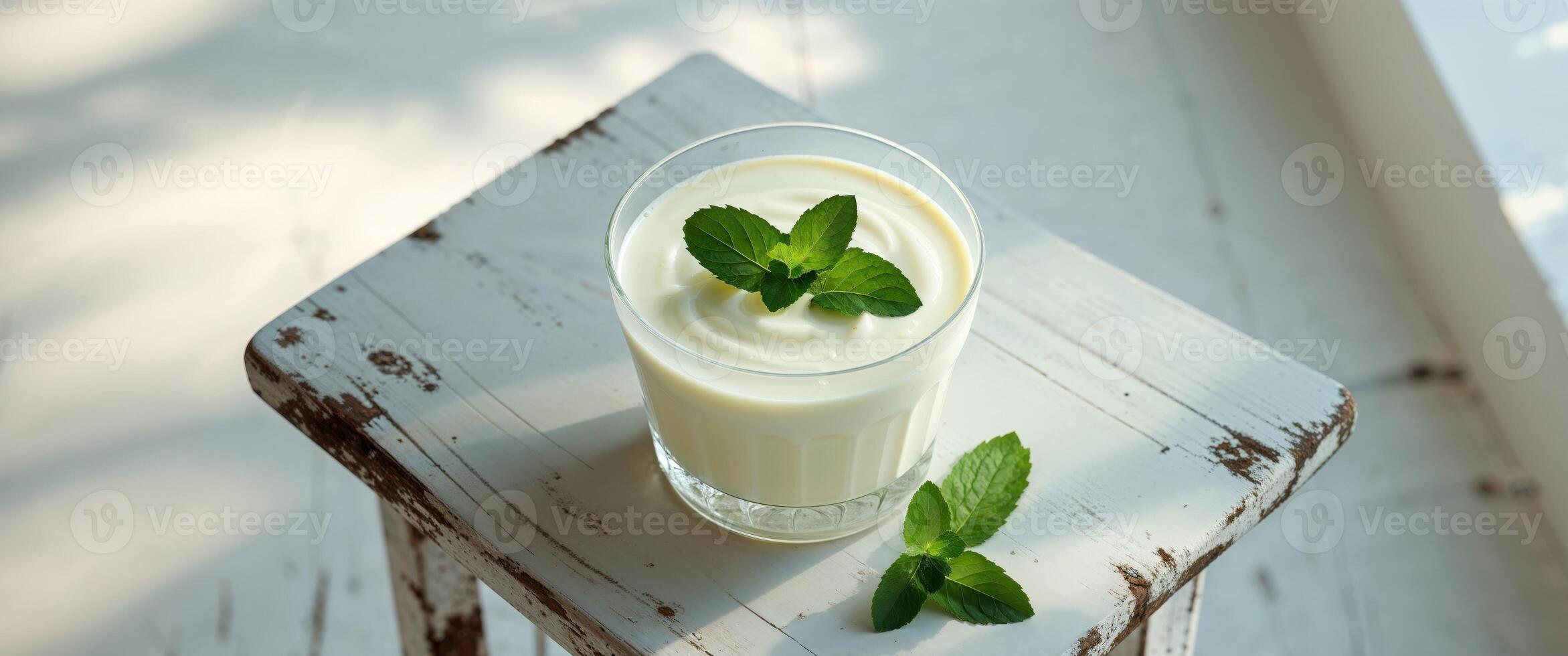Refreshing Yogurt Drink with Mint Garnish on a Table. photo