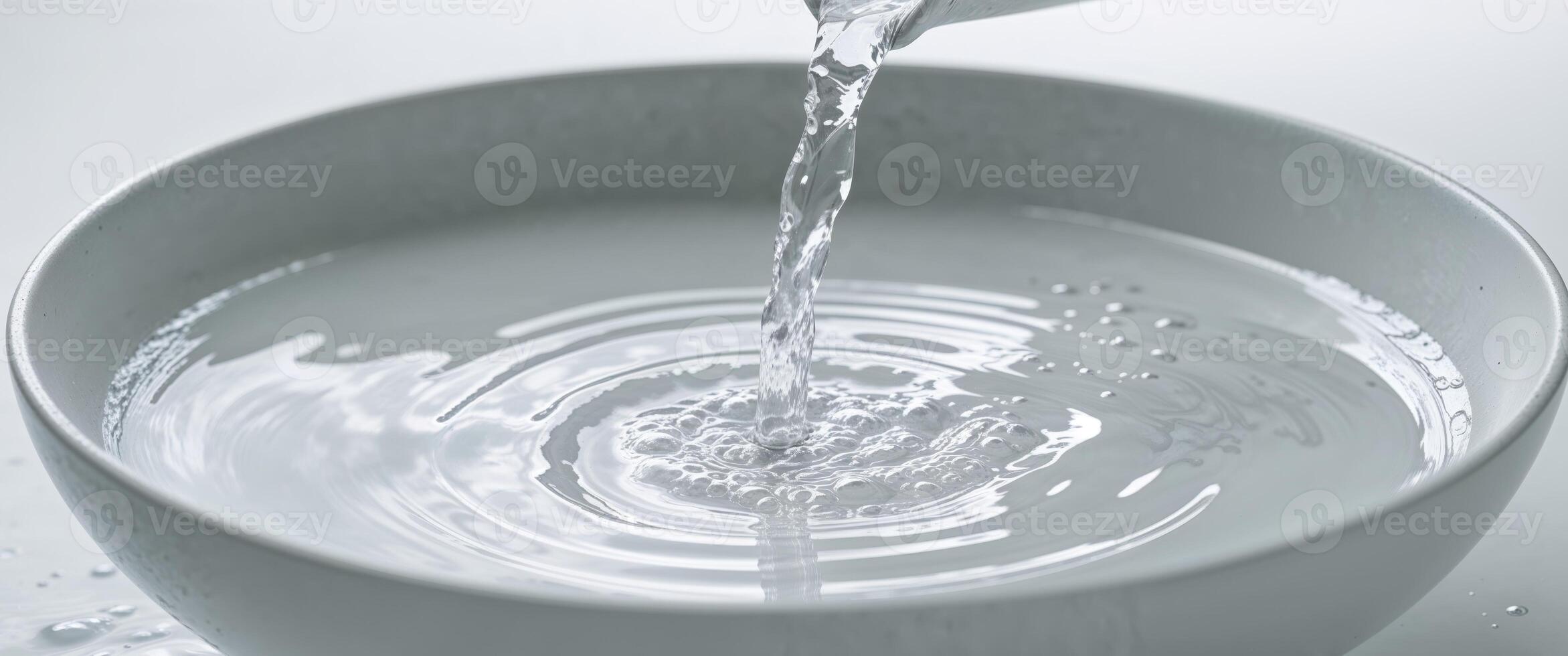 Water Pouring into White Bowl Creating Ripples and Bubbles. photo