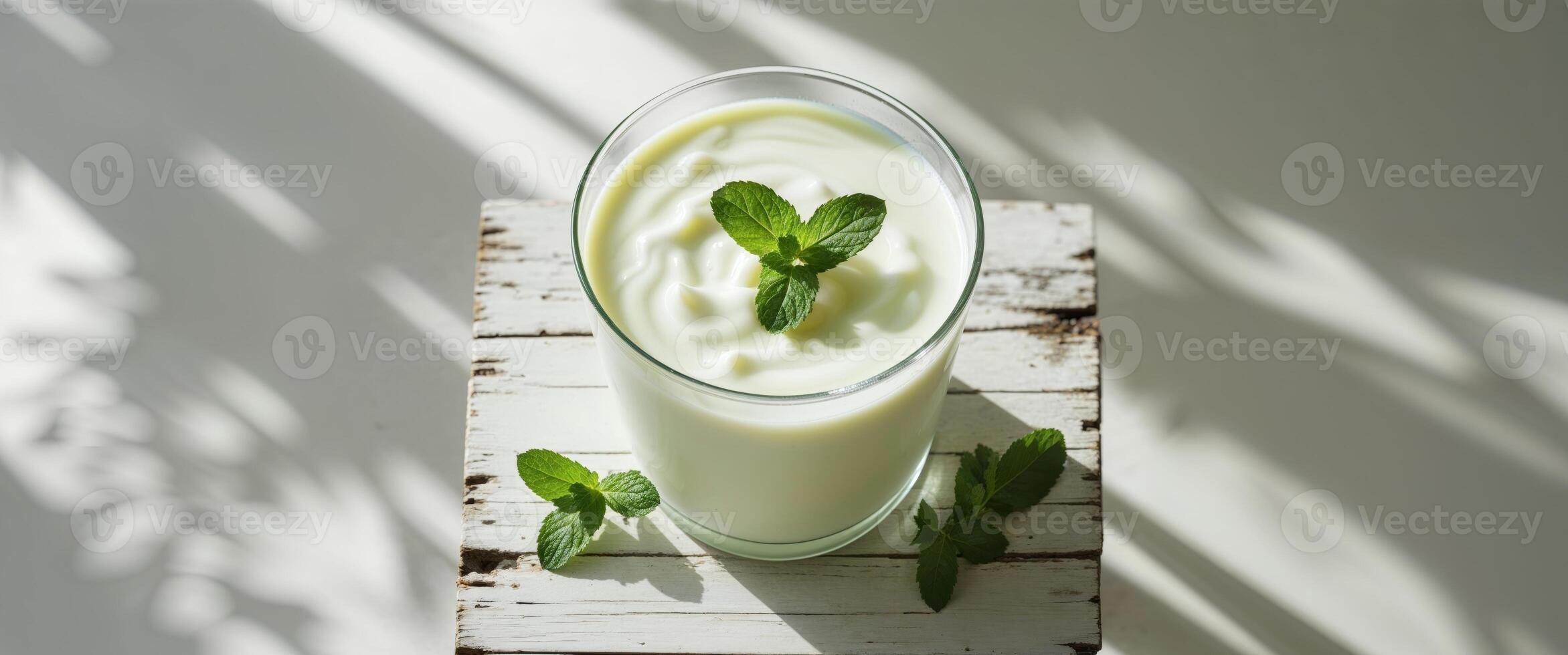 Refreshing Yogurt Drink with Mint Garnish on a Table photo