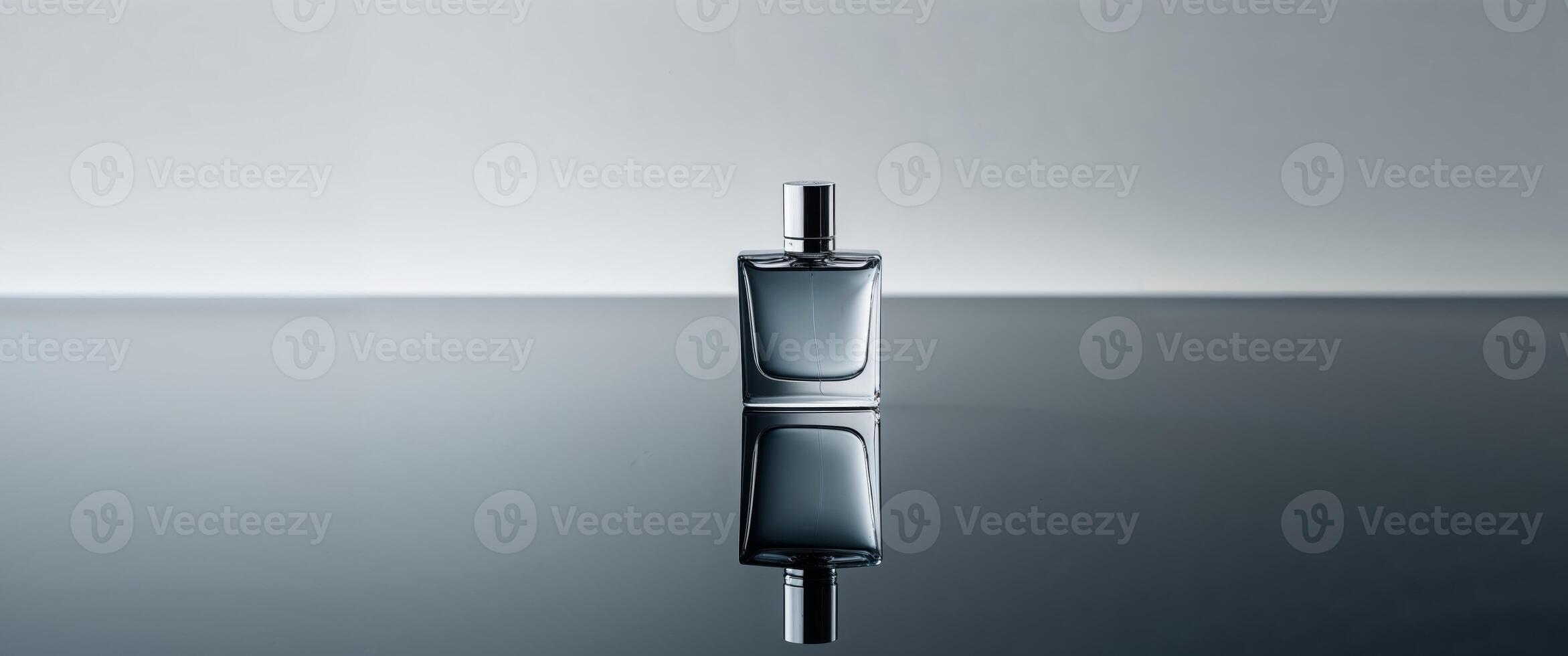 A beautifully designed perfume bottle sits on a reflective surface. photo