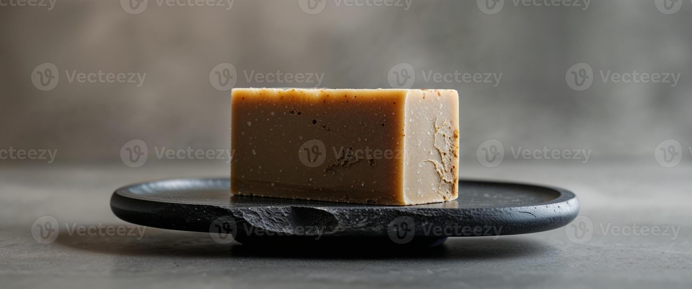 A soap bar sitting on a black plate photo