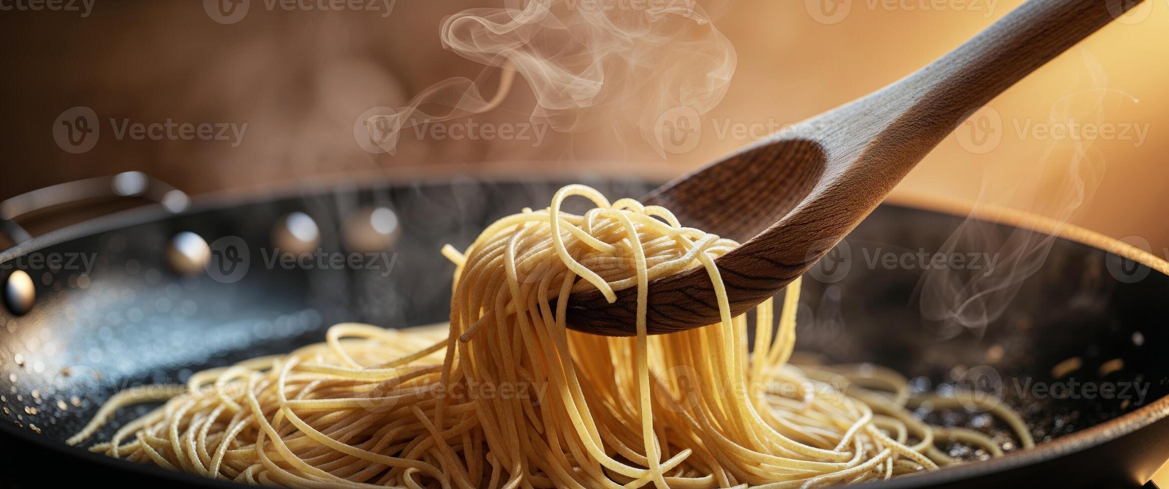A wooden spoon is stirring spaghetti in a pan photo