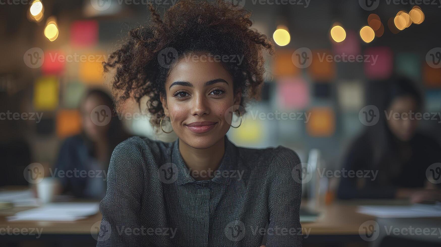 A woman with curly hair sitting at a table in an office photo